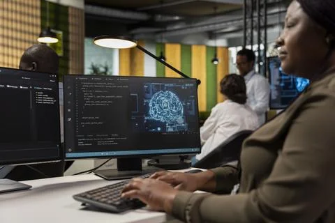 Software developer in office automating repetitive tasks using AI scripts on PC Stock Photos