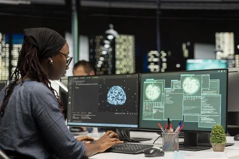 Software developer at office desk doing maintenance on servers using AI 스톡 사진