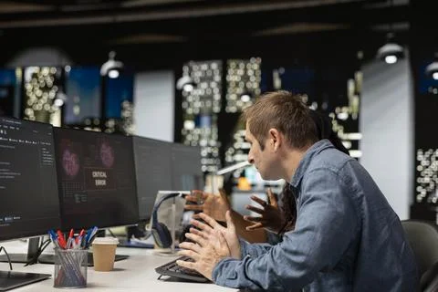 Software developer at office desk thinking how to fix critical error 스톡 사진