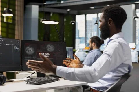 Software developer in office surprised by critical error warning popup Foto stock