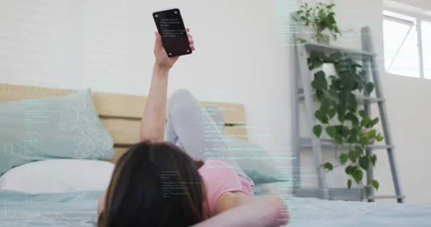 Software developer raising smartphone and scrolling code overlay while tilting Stock Footage 318668926