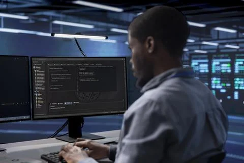 Software developer reconfiguring server farm to optimize it Stock Photos