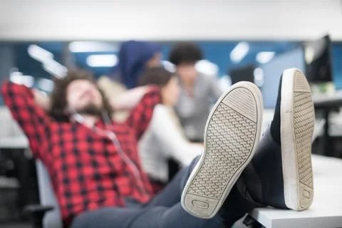 Software developer resting with legs on desk Foto stock