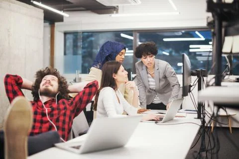 Software developer resting with legs on desk Stock Photos