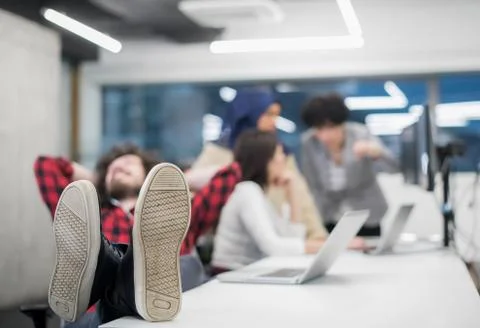 Software developer resting with legs on desk 스톡 사진