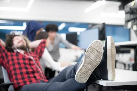 Software developer resting with legs on desk Foto stock