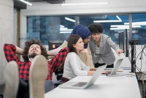 Software developer resting with legs on desk Foto stock