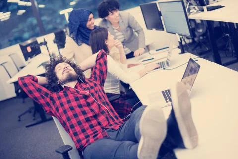 Software developer resting with legs on desk 스톡 사진