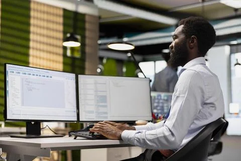 Software developer reviewing code snippets in modern workplace 库存照片