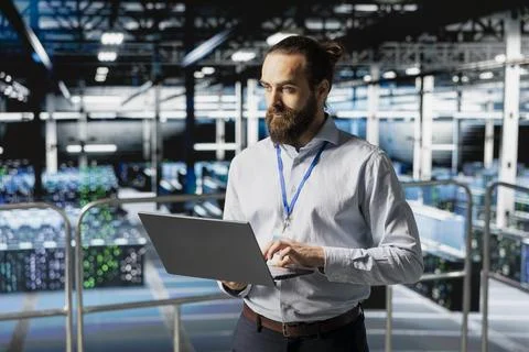 Software developer reviews data management for server rigs with tablet Foto stock