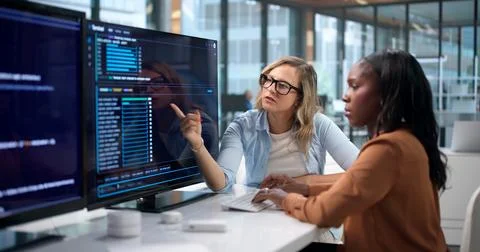 Software Developer Reviews Secure Cloud Code With Female Engineer Remotely. Fotos Stock