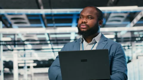 Software developer in server farm using laptop, doing network management Stock Footage 330087096