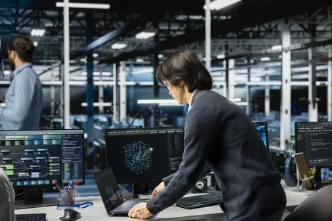 Software developer in server room using device to review diagnostics Stock Photos