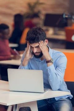 Software Developer sitting with laptop computer in startup office Stock Photos