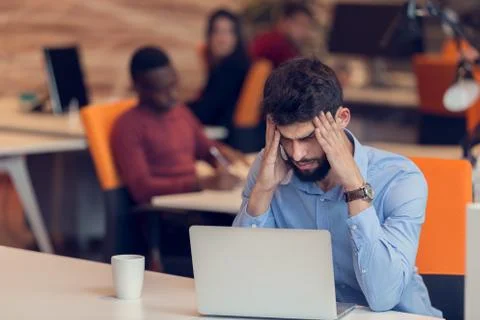 Software Developer sitting with laptop computer in startup office Stock Photos