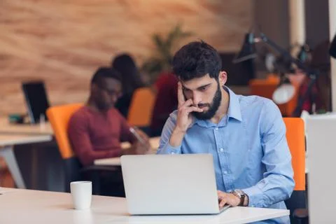 Software Developer sitting with laptop computer in startup office Stock Photos