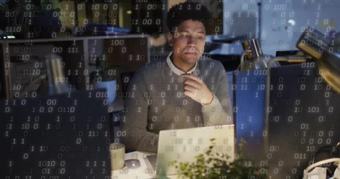 Software developer typing on laptop and studying code while binary overlay Stock Footage 330297222