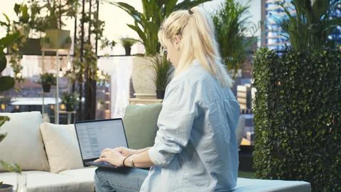 Software developer typing on laptop displaying binary code seated Stock Photos