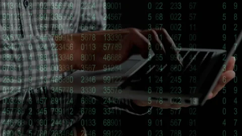 Software developer typing on laptop in tech studio, with animated green code Stock Footage 307858530