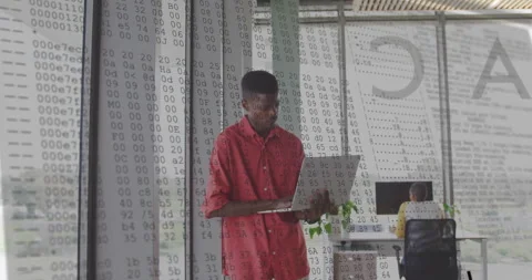 Software developer typing on laptop by window and animating code overlay across Stock Footage 310972886