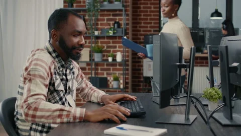 Software developer typing programming code on computer keyboard turning head and Stock Footage 168249500