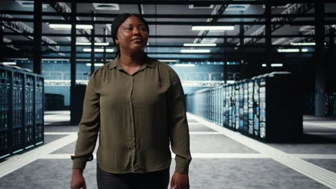 Software developer walking in data center, checking hardware Stock Footage 317125424