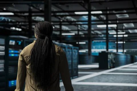 Software developer walking through server room rows 写真素材