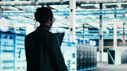 Software developer walks in data center, using tablet and AR technology Stock Footage 329592856