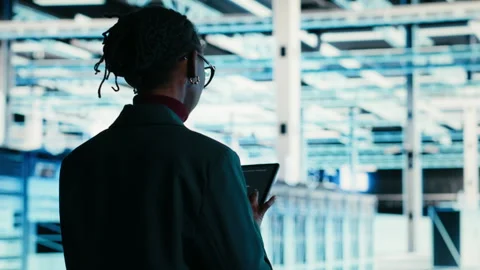 Software developer walks in data center, using tablet and AR technology Stock Footage 329652476