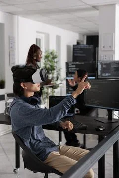 Software developer wearing virtual reality headset working to develop security Stock Photos
