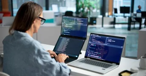 Software Developer Woman Coding On Dual Touchscreen Laptops Collaboratively. Stock Photos