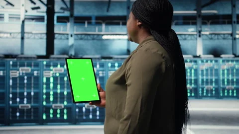 Software developer at work using green screen tablet in data center Stock Footage 317124486
