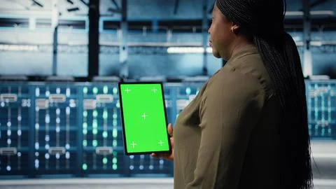 Software developer at work using green screen tablet in data center Stock Photos