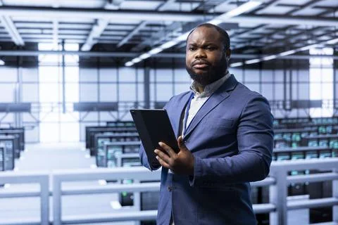 Software developer working in data center facility housing storage rackmounts Stock Photos