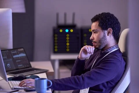 Software developer working at night writing code at desk Stock Photos