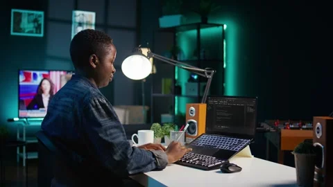 Software developer writes code on laptop screen while in apartment office Stock Footage 319529138