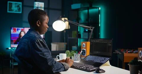 Software developer writes code on laptop screen while in apartment office Stock Photos