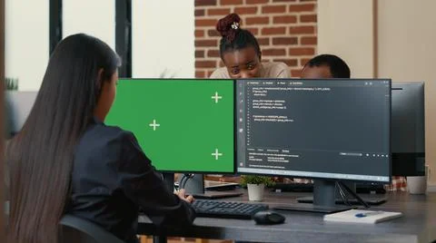 Software developer writing algorithm in front of computer with green screen Stock Photos
