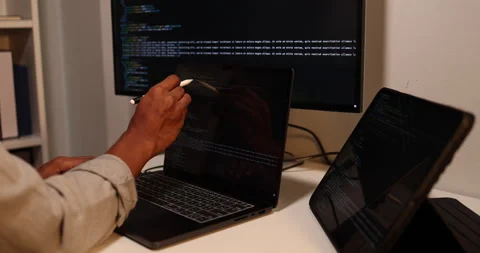 Software developer writing, reviewing and debugging source code Stockbeeldmateriaal 343540202