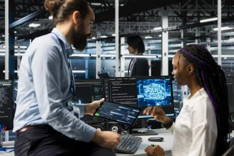 Software developers coding in data center, updating AI automation scripts Stock Photos
