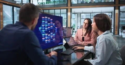 Software Developers Collaborate On Laptops Using Low Code Platform Tools. Фото