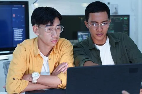 Software Developers Collaborating on Laptop in Modern Technology Office Stock Photos