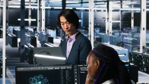 Software developers cooperating in data center, reviewing AI diagnostics Stock Footage 313567699