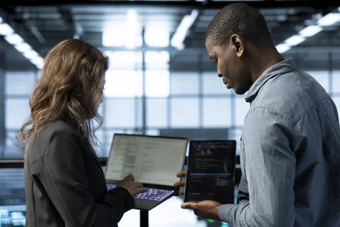 Software developers in data center coding on laptop Stockfoto's