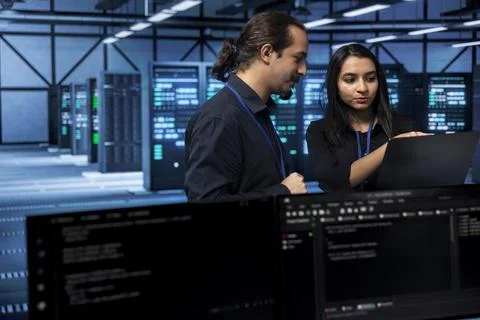 Software developers in data center running system diagnostic tests Foto stock