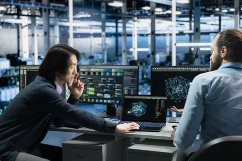 Software developers in data center troubleshooting connectivity issues using AI Stock Photos