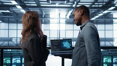 Software developers in data center using laptop, employing AI machine learning Stock Photos