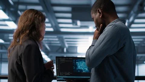 Software developers in data center using laptop, employing AI machine learning Stock Photos