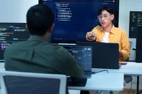 Software Developers Discuss Coding and Artificial Intelligence Stock Photos