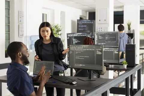 Software developers discussing website code in startup office Stock Photos